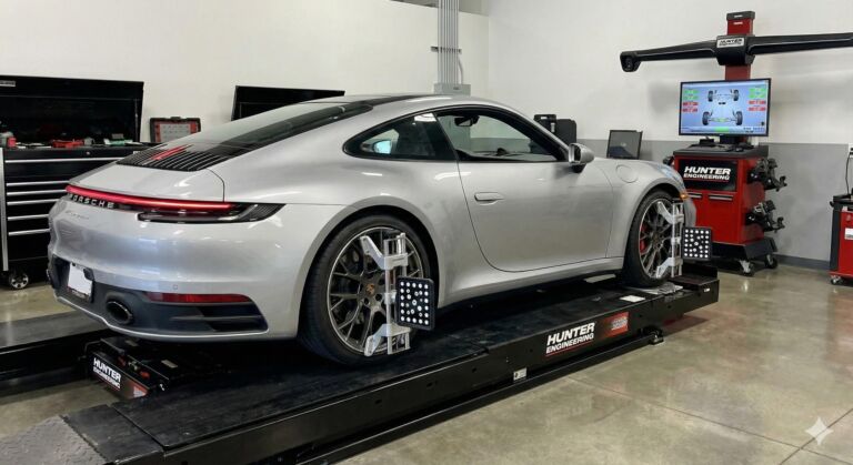 A silver sports car on a lift in a garage
